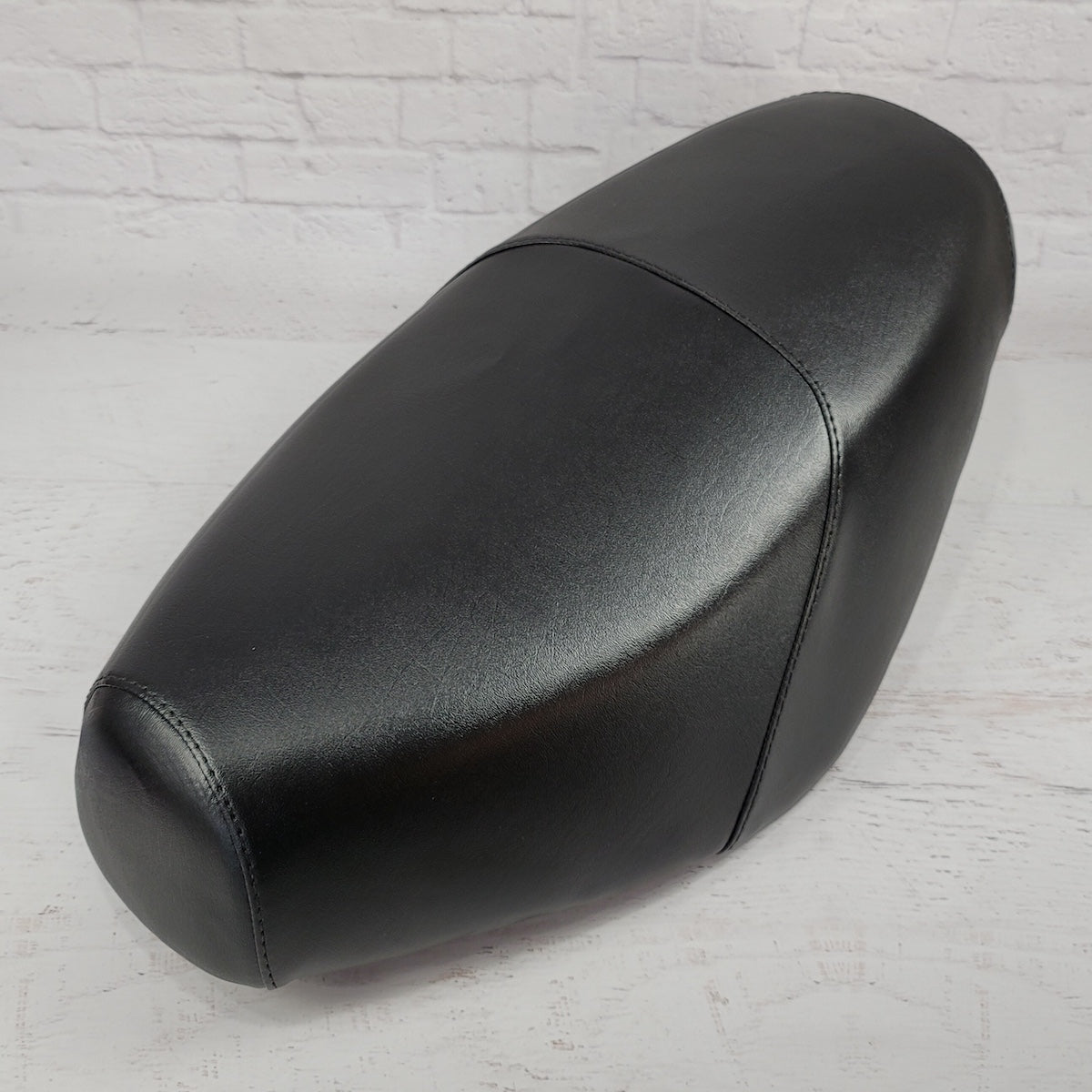 Cheeky Seats classic black cover on a Genuine Buddy standard seat, front three-quarter product view