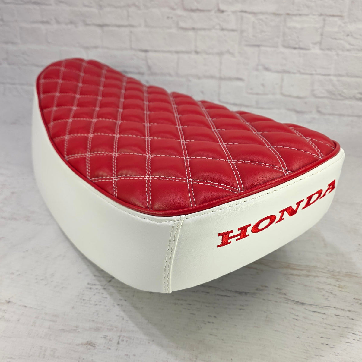 Rear view of a Honda Dax seat cover - in red with diamond stitching white sides and red embroidered Honda logo, handmade by Cheeky Seats
