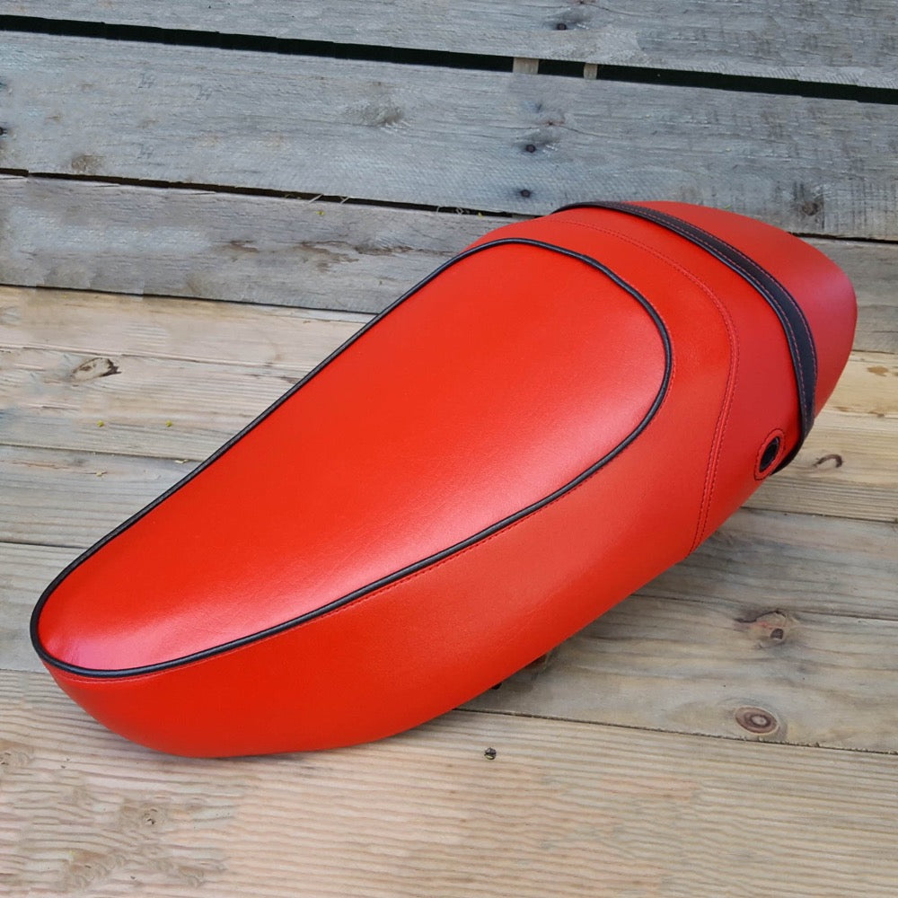 Red Vespa S sport-saddle seat cover with black piping and black strap, handmade by Cheeky Seats