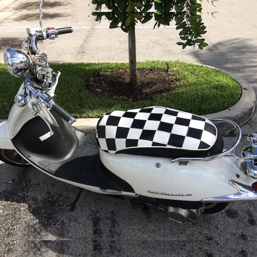 Black-and-white checkerboard seat cover installed on a white Lance Cali Classic scooter, handmade by Cheeky Seats