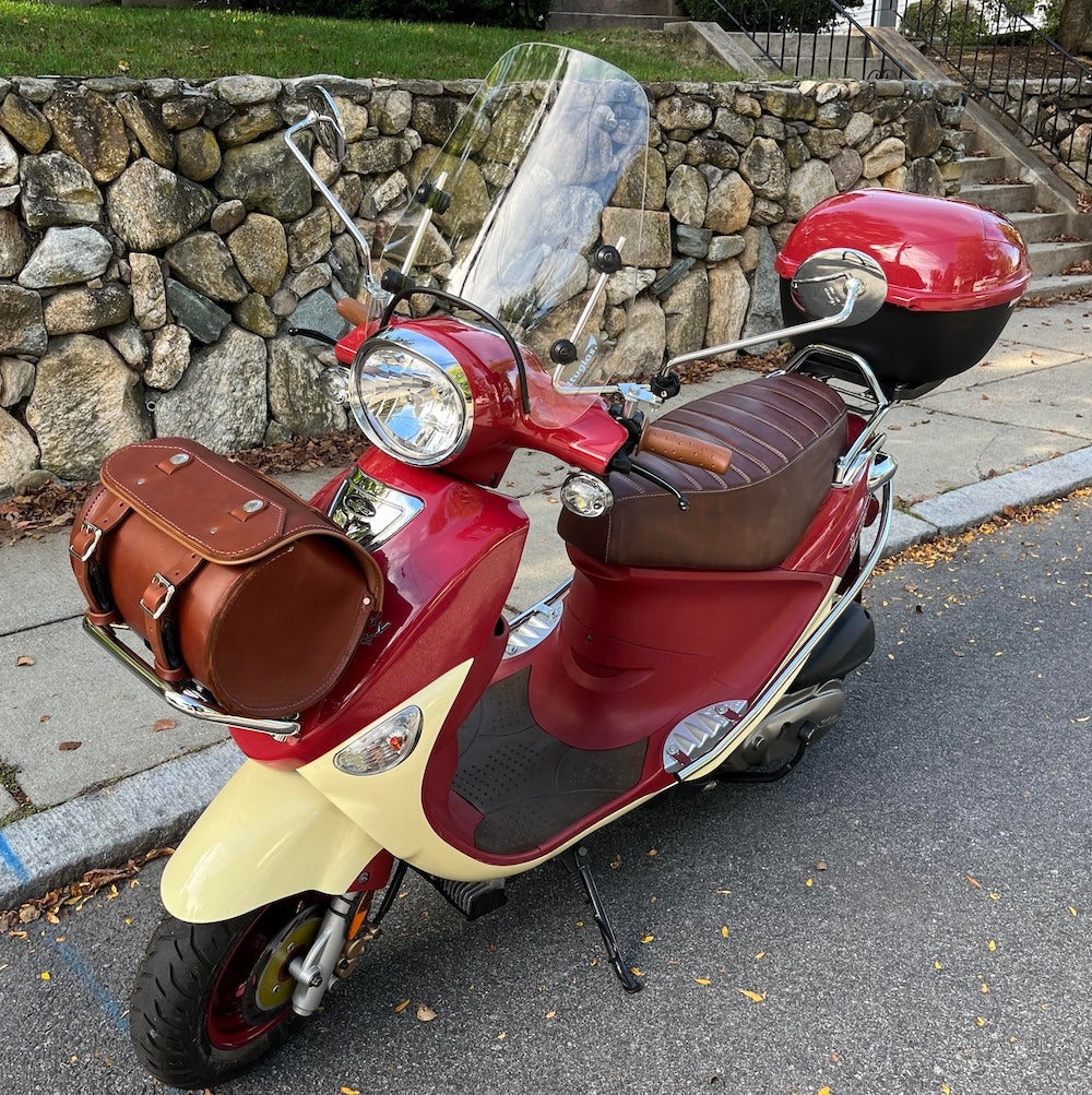Red-and-cream Genuine Buddy fitted with a whiskey-brown tuck-and-roll Cheeky Seats cover and leather accessories