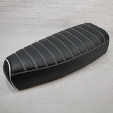 Black Genuine Stella tuck-and-roll seat cover with white stitching and piping, handmade by Cheeky Seats
