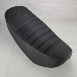 Black BRIDE fabric Honda DAX 125 tuck-and-roll seat cover with tonal stitching and black sides, handmade by Cheeky Seats