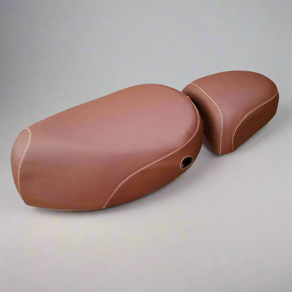 Two-piece cinnamon brown seat cover set for the Kymco People 50 laid out on a gray backdrop, driver seat and passenger pillion both showing tan contrast stitching, handmade by Cheeky Seats