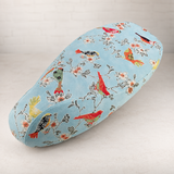 Songbirds Vespa seat cover with birds perched among flowering branches on a pale blue background, handmade by Cheeky Seats.