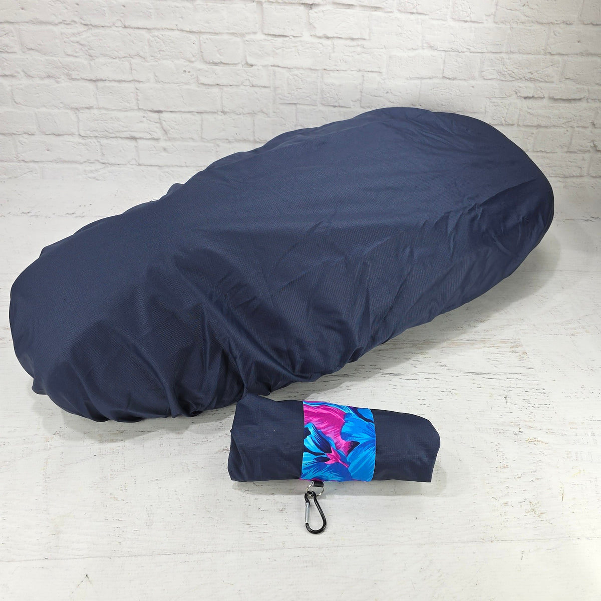 Navy rain and elements cover for Piaggio Fly and Liberty seats with a blue floral carry pouch and clip, by Cheeky Seats