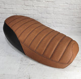 Front three-quarter view of an Anti slip distressed Slickrock brown Yamaha Zuma II BWS 49/50 Prebug tuck-and-roll seat cover with black rear panels, handmade by Cheeky Seats