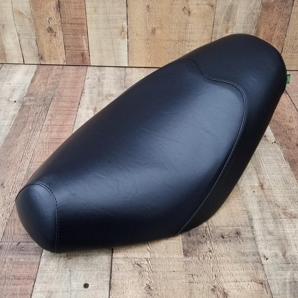 Classic black Cheeky Seats cover shaped over a Genuine Buddy low-profile seat, left-front studio view
